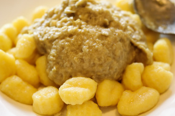 Primo piano di un piatto di gnocchi di patate con sugo ai carciofi, cibo e cucina