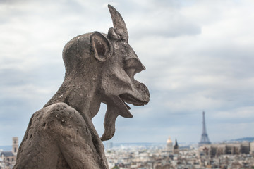 Famous Notre Dame gargoyle overlooking the Paris cityscape
