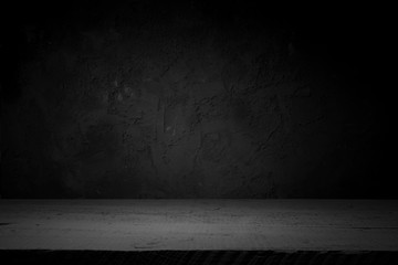 cement floor in dark room with spot light. black background.