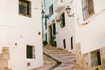 Fototapeta na wymiar Beautiful narrow street in the old town with white houses and a cobblestone road. Altea, Spain