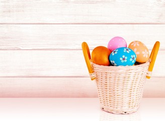 Easter basket filled with colorful eggs on a white background