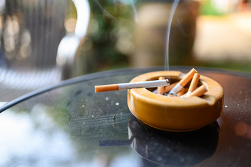 Cigarette burning with smoking on ashtray