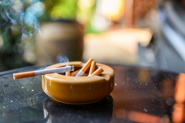 Cigarette burning with smoking on ashtray
