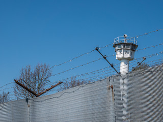 Stacheldrahtzaun mit Wachturm der ehemaligen DDR