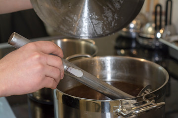 Cook interferes with the sauce in the professional kitchen of the restaurant