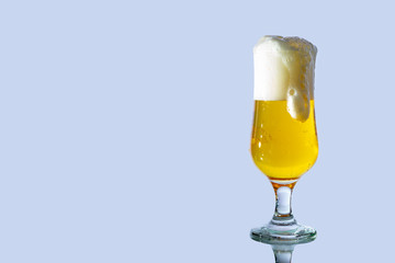 A fresh glass of beer with a lot of foam, which runs down the glass, photographed isolated