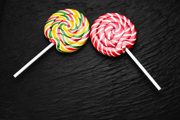 red and yellow round lollipops on black background with texture