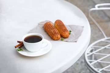 Fragrant coffee with eclairs in the summer cafe.