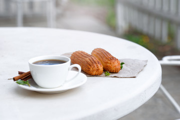 Fragrant coffee with eclairs in the summer cafe.