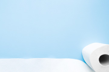 Soft, white toilet paper roll on light pastel blue background. Hygiene concept. Empty place for text, object or logo. 