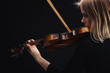 young concentrated woman playing cello with bow isolated on black with copy space © LIGHTFIELD STUDIOS