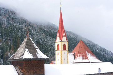 The Maria Hilf parish church of Selva with the cemetery and tombs in the foreground, Val Gardena,...