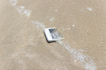 White Mobile phone floated to the sea at the beach.
