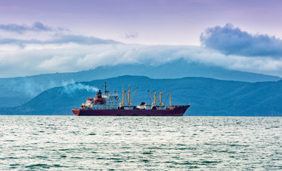 fishing boat in gray morning on Pacific ocean off the coast of the Kamchatka Peninsula