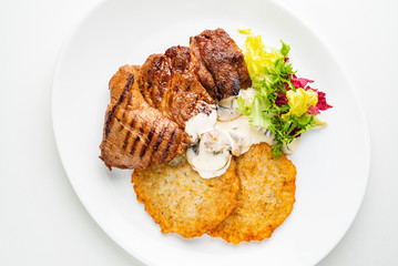 pork steak with potato pancakes and salad