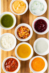 Bowls with sauces on wooden tray
