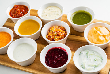 Bowls with sauces on wooden tray