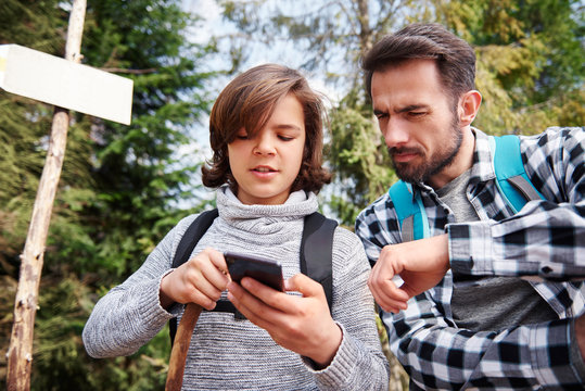Father and son choosing the best footpath for hiking - Powered by Adobe