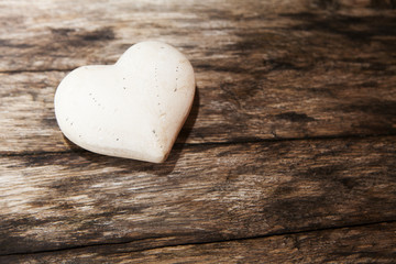 coeur en pierre blanche sur fond de bois