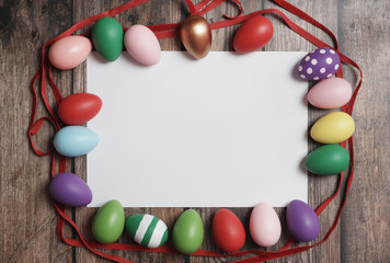 Flat-lay colorful Easter eggs on wooden table copy-space.