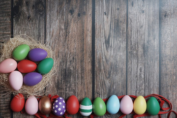 Flat-lay colorful Easter eggs on wooden table copy-space.