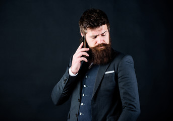 Searching for right decision. Bearded man with smartphone. brutal caucasian hipster. businessman in suit. Male formal fashion. business communication. Mature hipster with beard speak on phone