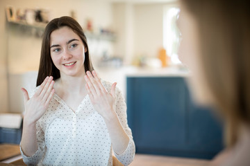 Two Teenage Girls Having Conversation Using Sign Language