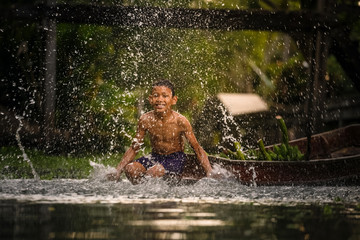 Boy swimming in the cannal near the Damnoen Saduak Floating Market