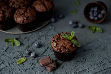 Chocolate muffins with blueberries on a dark background. Chocolate brownies.