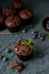 Chocolate muffins with blueberries on a dark background. Chocolate brownies.