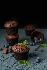 Chocolate muffins with blueberries on a dark background. Chocolate brownies.