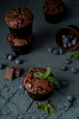 Chocolate muffins with blueberries on a dark background. Chocolate brownies.