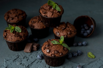 Chocolate muffins with blueberries on a dark background. Chocolate brownies.