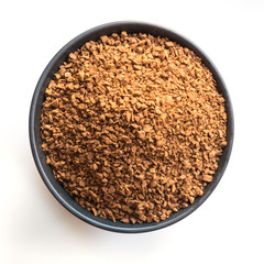 Granulated soluble coffee in bowl on white. View from above.