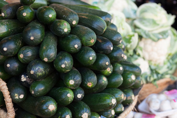 Fresh zucchini on market counter in wicker basket