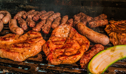Juicy pork steaks, sausages and minced meat cevapcici on charcoal barbecue.