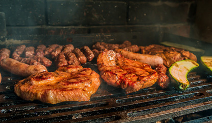 Juicy pork steaks, sausages and minced meat cevapcici on charcoal barbecue.