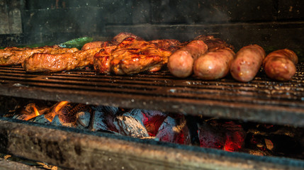 Juicy pork steaks, sausages and minced meat cevapcici on charcoal barbecue.