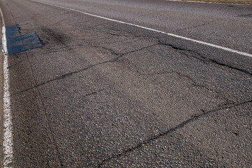 Fototapeta premium Old asphalt road with cracks