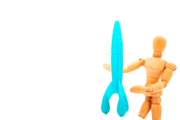 blue plastic space craft holding by wooden figure on white background, explorer and education concept