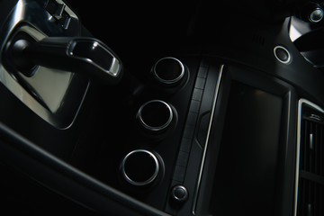 black buttons near modern car dashboard and gear shift in automobile