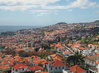 Naklejka na ściany i meble overhead panoramic view of the city of funchal in madeira with roofs and landmarks of the city visible in front of the sea