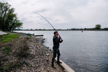 Fisherman throws spinning in the river on a sunny day