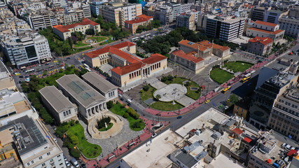Naklejka premium Aerial drone photo of trilogy neoclassic buildings, Academy of Athens, University and public library and Lycabettus hill at the background, Athens, Attica, Greece
