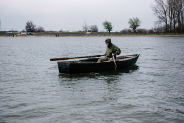 Fototapeta na wymiar A man is rowing in a wooden boat