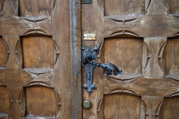 Antique door knob with "Drag" inscription. wooden door
