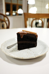 Chocolate cake with cinnamon stick in white table bright background.