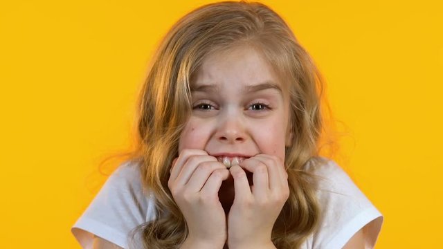 Little nervous girl is afraid of big stage and performance in public, close-up