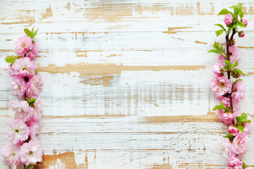 Bunch of spring flowering branches with a lot of white-pink blossoms on wooden background. Rustic composition w/ spring flowers on vintage textured wood table. Close up, copy space, top view.