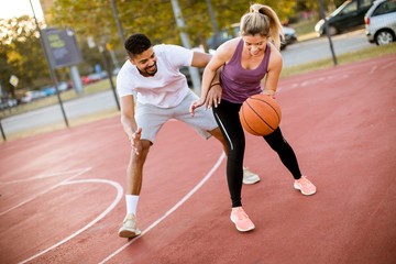 Group of multiethnic people  playing basketball on court